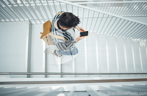 Image of Phone, stairs and education with a student man walking down a staircase at university or college. Mobile, study and top view with a male pupil taking steps to get to class for learning or development