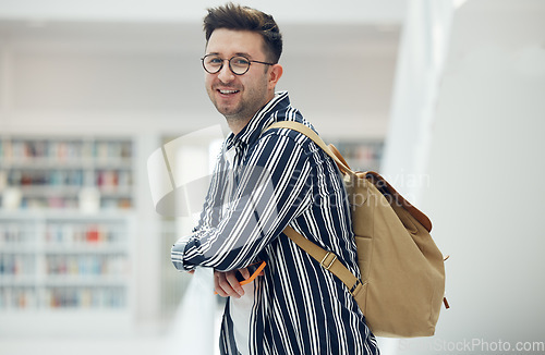 Image of Portrait, library and student at university, college or academy for research, learning and knowledge with smile for scholarship. Study, education and creative, geek man with backpack and school goals