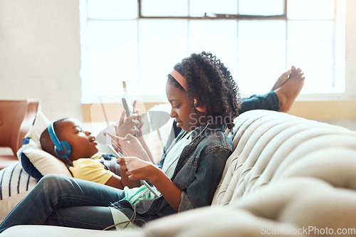 Image of Phone, family and brother sister relax on a sofa, online and home entertainment while sitting in a lounge. Internet, siblings and girl with boy on a couch, online and entertainment in a living room