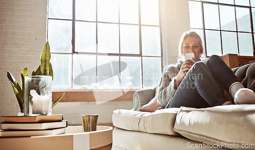 Image of Living room, phone or relax and a woman in her home, sitting on the sofa with the sun shine through the window. Weekend, social media and communication with a young female relaxing in her house