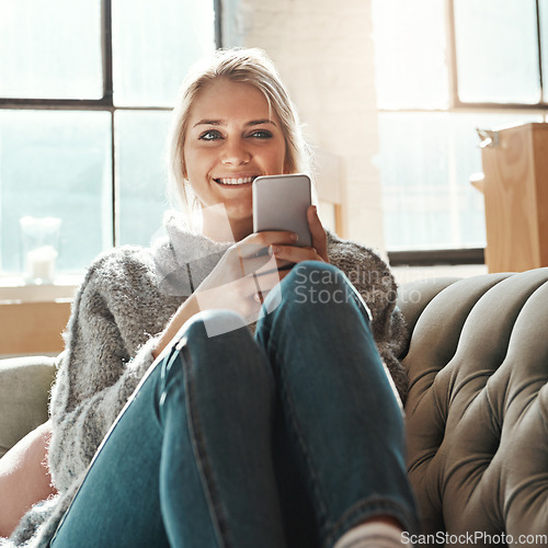 Image of Smile, woman and phone on a home sofa with lens flare and happiness in the sun on wifi. Mobile, social media scroll and mobile phone internet of a person on a house couch in a living room happy