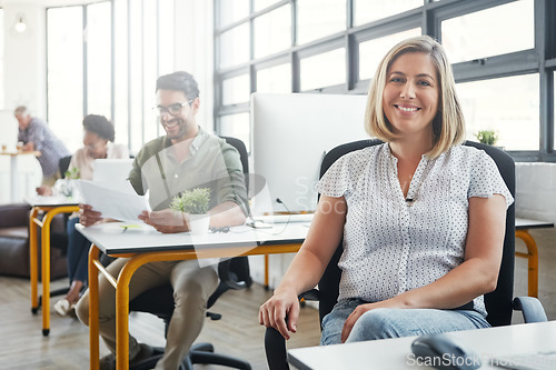 Image of Business woman, smile and sitting at the desk happy for career, vision or ambition at office. Portrait of young female designer smiling in happiness for job, profession or occupation at the workplace