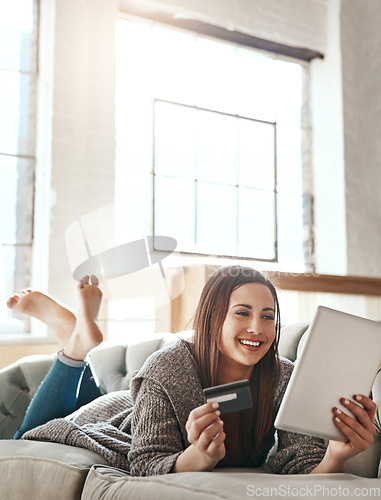 Image of Digital tablet, credit card and woman on a sofa for online shopping, ecommerce and payment while relaxing. Girl, couch and online banking from app, purchase and booking online in a living room