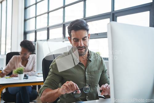 Image of Working, business man and computer typing of a marketing employee in a office. Thinking, businessman and coworking workplace of a worker doing website ux strategy research cleaning glasses to work