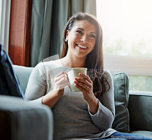 Image of Coffee, thinking and relax with a woman in her home, sitting on a sofa in the living room feeling happy. Idea, tea and lifestyle with an attractive young female relaxing on a couch in her lounge
