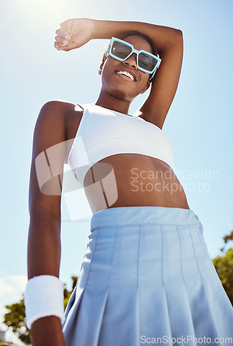 Image of Fashion, sports and black woman posing outdoor with cool, edgy and stylish outfit and sunglasses. Happy, smile and African female model with edgy, funky and fashionable style standing on tennis court