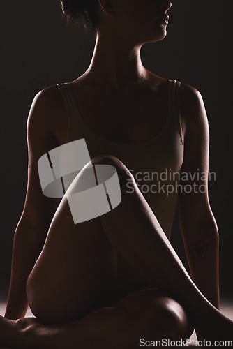 Image of Beauty, body and silhouette of a woman in a studio with a creative, mysterious and seductive aesthetic. Art, fantasy and shadow figure of a female model with a sexy pose by a dark black background.