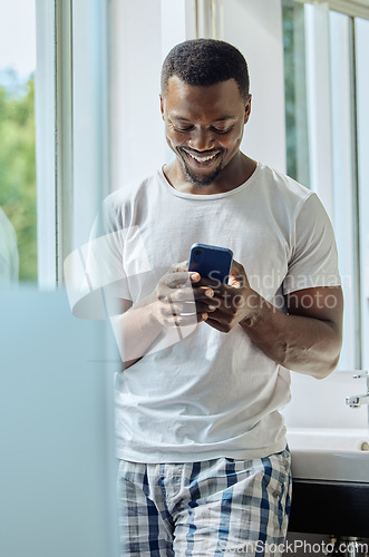 Image of Bathroom, phone and black man in home on social media, texting or internet browsing. Cellphone, relax or happy male holding mobile smartphone for web scrolling, networking or messaging alone in house