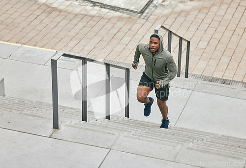 Image of Runner, fitness and city stairs with a sports black man in the city for a cardio or endurance workout. Training, exercise or motivation with a male athlete running or moving up an urban staricase