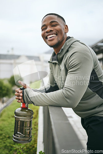 Image of Fitness, happy or black man with smile or pride after body training, exercise or workout with a water bottle in Miami. Portrait, relaxing or healthy sports athlete with wellness goals or motivation