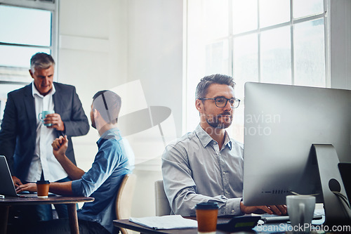 Image of Computer, work and businessman with his colleagues in the background talking, speaking and planning. Pc, success and professional male employee working on a corporate company report in the office.