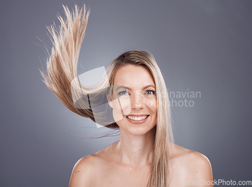 Image of Portrait, beauty and hair with a model woman in studio on a gray background for keratin treatment or natural haircare. Face, skincare and wellness with a female posing to promote a haircare product