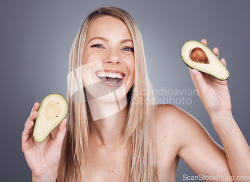 Image of Portrait, beauty and avocado with a model woman in studio on a gray background for natural treatment. Face, skincare and nutrition with an attractive young female posing to promote skin antioxidants