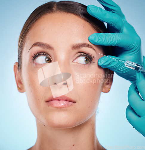 Image of Plastic surgery, skincare and woman with injection, healthcare and on blue studio background. Female, girl and botox with cosmetics, wellness and face care for health, soft and smooth skin for beauty