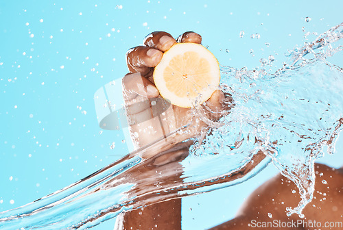 Image of Water splash, lemon and man beauty with hands for healthy skincare, wellness and dermatology. Vitamin c, citrus fruits and shower on blue background for natural diet, water drops and detox cosmetics