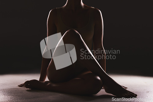 Image of Beauty, silhouette and body of a woman in a studio with a creative, mysterious and seductive aesthetic. Art, fantasy and shadow figure of a female model with a sexy pose by a dark black background.