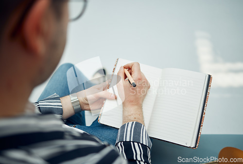 Image of Top view, man and writing in notebook, planning and focus on schedule, solutions and essay. Male student, academic and writer with diary, journal and pen for studying, creative and thinking with book