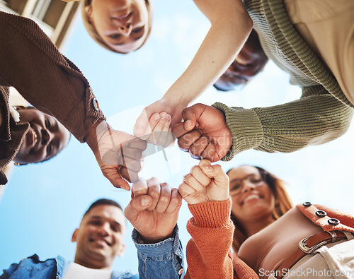 Image of Group of friends, hands bump in huddle and group diversity, team building circle from below. Friendship, happiness and university students in fist bump, men and women smile together on college campus