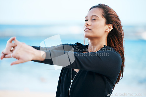 Image of Young woman stretching on beach, relax on summer holiday and peaceful blue sky in Mauritius. Calm female tourist meditating on seaside, healthy outdoor yoga and girl breathing fresh ocean air