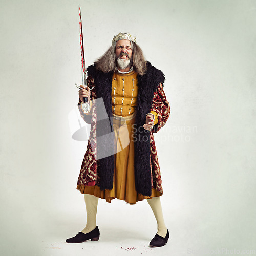 Image of King, portrait and man with bloody sword in studio isolated on a gray background mock up. Victorian villain, medieval royal or mature male, evil ruler or angry leader holding steel blade after battle