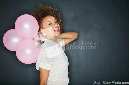 Image of Black woman, portrait and balloons in studio for fun, personality and celebration on black background. Face, balloon and girl celebrating party, birthday or playful aesthetic while standing isolated