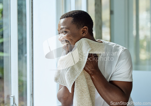 Image of Black man, skincare and towel after washing face in home bathroom for clean and healthy skin with dermatology. Male happy after a facial, shower or cleaning body with water for hygiene and wellness