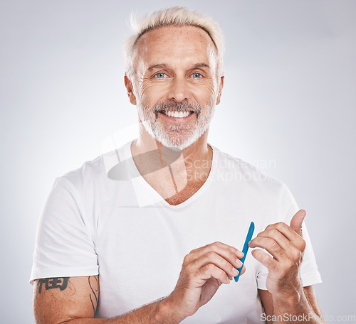 Image of Portrait, nail file and beauty with a man in studio on gray background mockup for grooming, filing his finger nails. Manicure, wellness and cosmetics with a male taking care of his personal hygiene