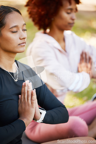 Image of Women friends, namaste hands and yoga meditation at park, wellness and freedom of chakra energy, zen fitness or peace. Calm girls, relax exercise and meditate with prayer in nature for mental health