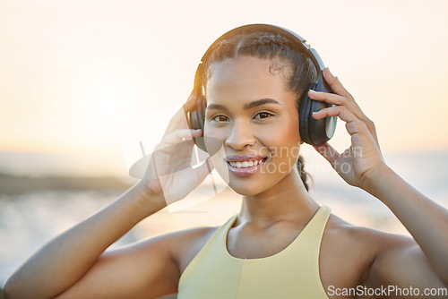 Image of Fitness, music or happy woman at beach for running training, exercise or workout at sunset in Brazil. Portrait, sports athlete or healthy girl runner listening to podcast or radio audio in headphones