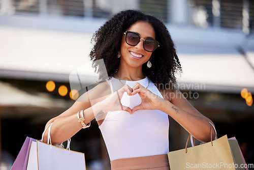 Image of Heart, portrait and woman with love for shopping, retail support and smile for fashion discount in the city of Miami. Happy, emoji and girl with hand sign in the street for a shopping bag sale