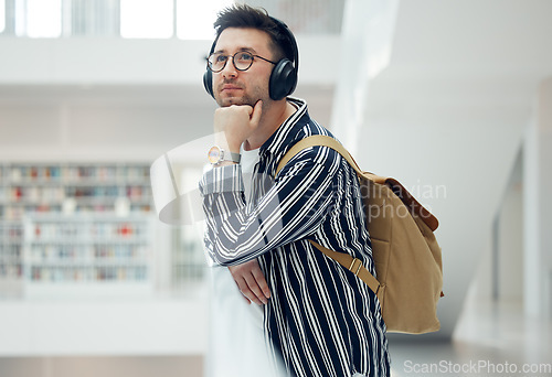 Image of Thinking, headphones and library student at university, college or academy idea for research, learning and knowledge. Study, education and creative, geek man listening to audio for school inspiration