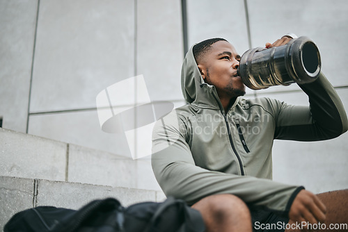 Image of Fitness, relax or black man drinking water in training or exercise for body recovery or workout in Chicago, USA. Hydration, thirsty or tired healthy sports athlete drinks natural liquid in bottle