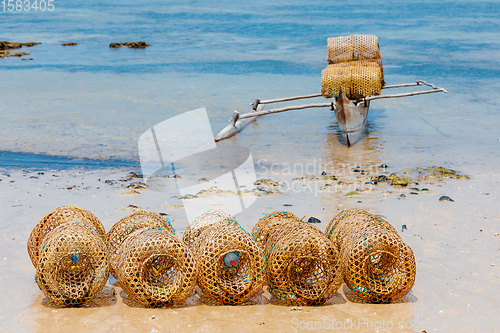 Image of traditional malagasy fishing boat with trap on beach