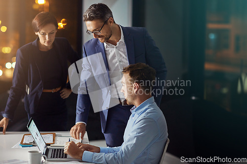 Image of Business people, laptop and meeting working at night in office for big data collaboration, planning overtime and report deadline. Teamwork, late and digital tech conversation with web design leader