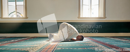 Image of Mosque, worship and muslim man in prayer on his knees for gratitude, support or ramadan for spiritual wellness. Religion, tradition and islamic guy praying or reciting quran to allah at islam temple.