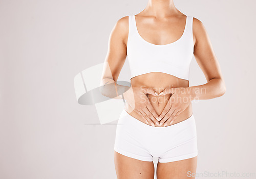 Image of Health, body and hands in heart of a woman with lose weight results, fitness and beauty goals on studio white background. Underwear, skincare and model woman with gut health, stomach and diet mockup