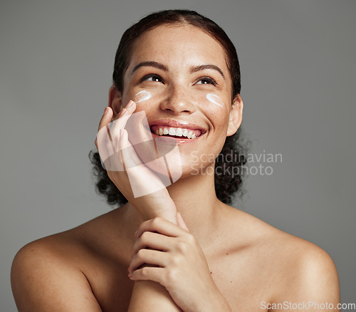 Image of Skincare, face beauty and woman with cream for acne, dermatology and glow on a studio background. Spa, sunscreen and model thinking of a cosmetics product for dermatology and facial wellness