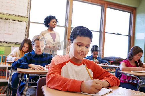 Image of Children, education or kids in classroom writing in notebook for learning, research or study for exam with teacher. Scholarship, thinking or students happy in school for test, academy or assessment