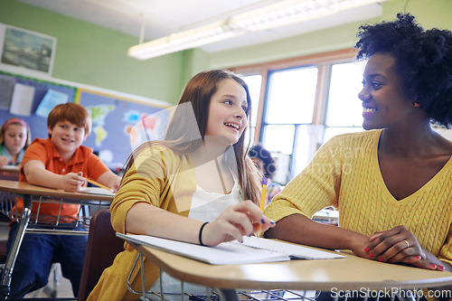 Image of Learning, education and teacher help student with assignment in elementary school. Classroom support, scholarship and happy black woman or educator aid, explaining and helping girl learner in class.