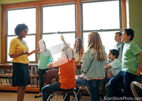 Image of Learning, education and student with questions for teacher in middle school classroom. Library, scholarship group and male learner raising hand to answer question, studying or help with black woman.