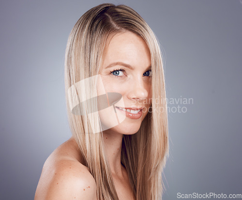 Image of Portrait, beauty and hair with a model woman in studio on a gray background for keratin treatment or natural haircare. Face, skincare and wellness with a female posing to promote a haircare product
