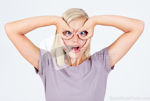 Image of Young woman, silly and fingers glasses, happiness and girl isolated on white studio background. Female, lady and creative with funny face, gesture and happy on backdrop, hands around eyes and fun