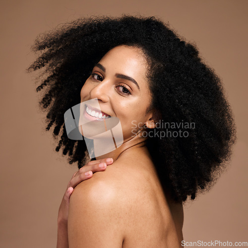 Image of Woman, face skincare or afro haircare on brown studio background in self love, healthcare wellness or body dermatology. Portrait, smile happy or beauty model and natural hairstyle or makeup cosmetics