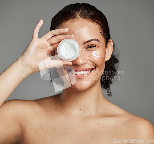 Image of Black woman, smile portrait and cream for beauty wellness shine, eyes cosmetic dermatology and spa product in grey studio. Happy African girl, facial moisturizer and spf sunscreen or luxury skin glow