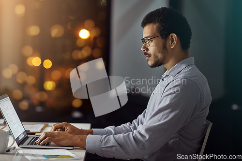 Image of Businessman, laptop and typing in research, analysis or web design on work desk at office. Employee man sitting and working on computer in overtime at night for dedication to meet project deadline