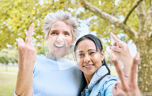 Image of Senior women, park portrait and hand sign for comic, funny and happy time together in nature. Old woman, friends and hands with peace, middle finger and laughing by trees, nature or forest to relax