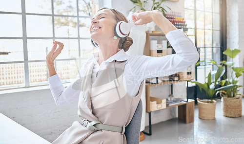 Image of Music, headphones and senior business woman dance in office, happy and excited about small business. Earphones, dancing and elderly female celebrate in design studio, cheerful and positive at a desk