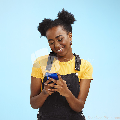 Image of Black woman with smartphone in hands, smile and happy with chat or social media, communication isolated on blue background. Technology, happiness and gen z youth, phone with internet wifi and mockup