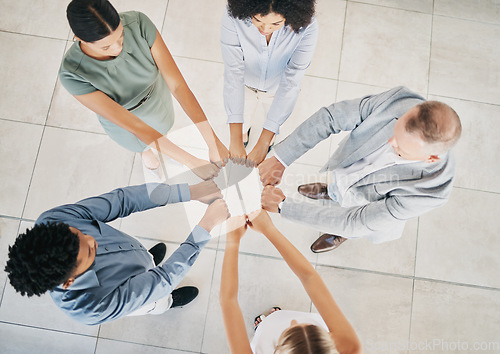 Image of Above, business people and fist bump circle in office for teamwork, motivation and support for success. Corporate group, vision and team building in workplace with diversity, solidarity and mission