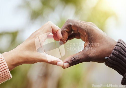 Image of Love, a couple and heart hand sign with nature, man and woman together with affection and diversity. Marriage, heart hands and a celebration of multiracial relationship with support and trust in park